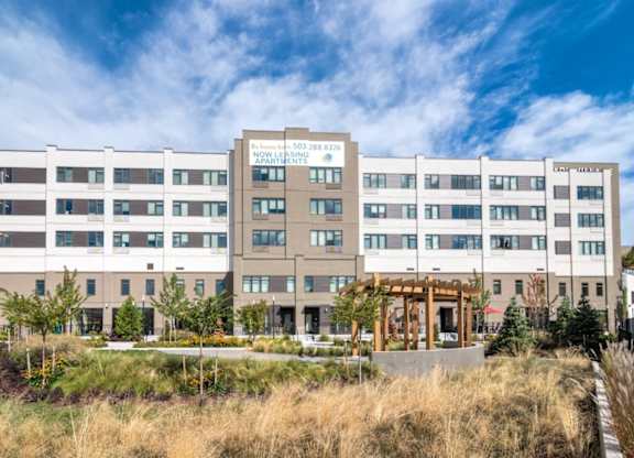 A modern building with a glass entrance and a sign that reads "Nowell Shores Apartments".