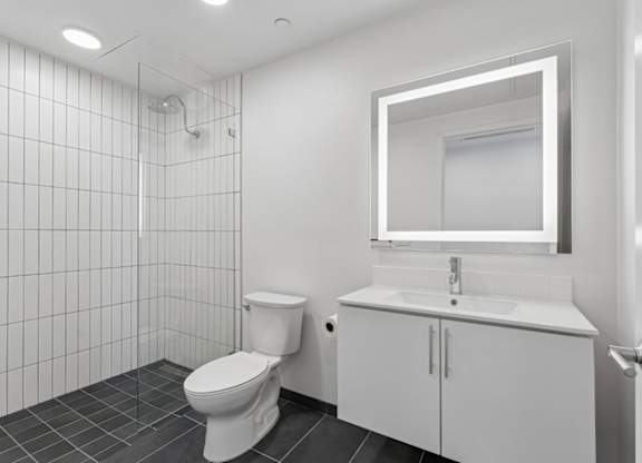 A white bathroom with a toilet, sink, and mirror.