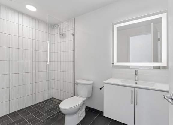 A white bathroom with a toilet, sink, and mirror.