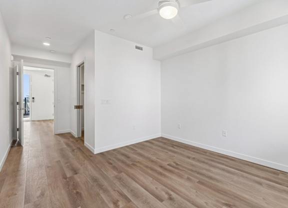 A room with wooden flooring and white walls.