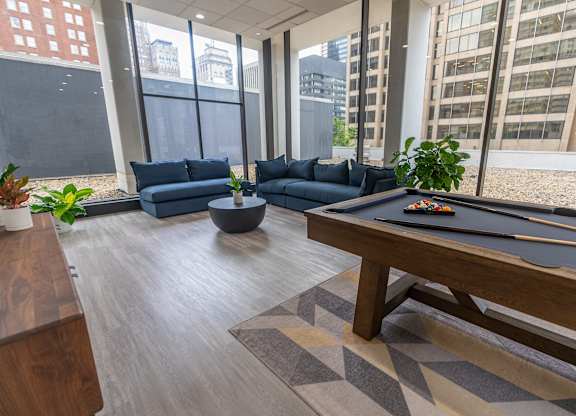 A pool table in a room with a view of the city.
