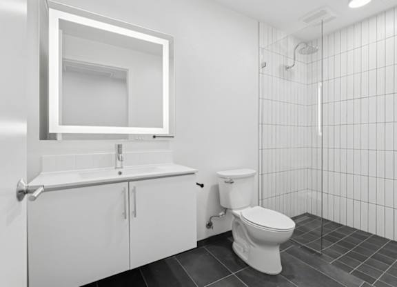 A white bathroom with a toilet, sink, and mirror.
