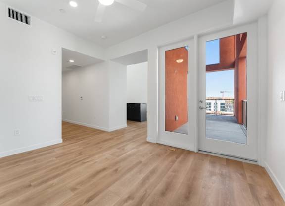 A room with a white wall and a wooden floor.