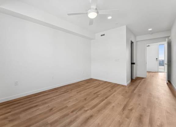 A room with wooden flooring and a ceiling fan.