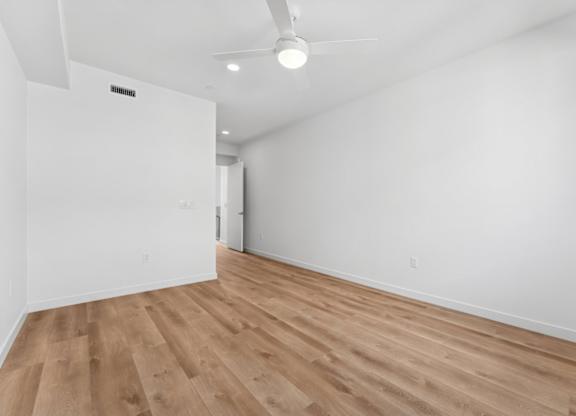 A room with wooden flooring and a ceiling fan.
