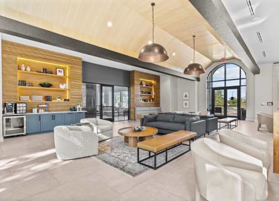 A modern living room with a large window and a kitchen area.
