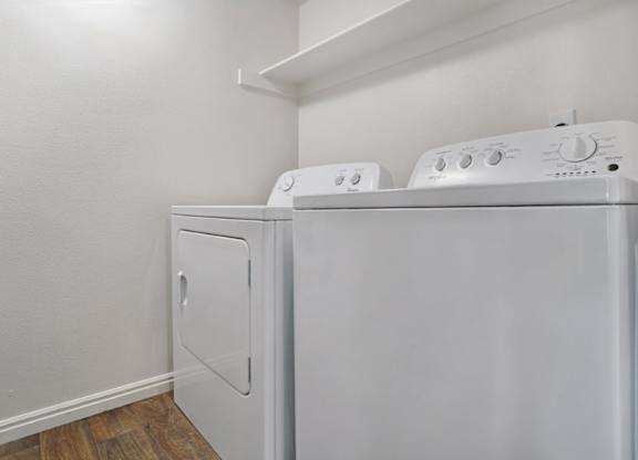 A white washing machine and dryer in a small room.