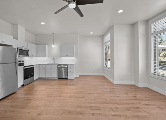an empty kitchen with white cabinets and stainless steel appliances