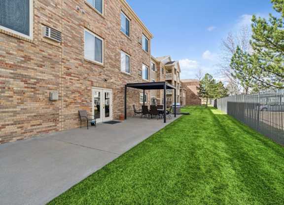 A long grassy area in front of a brick building.