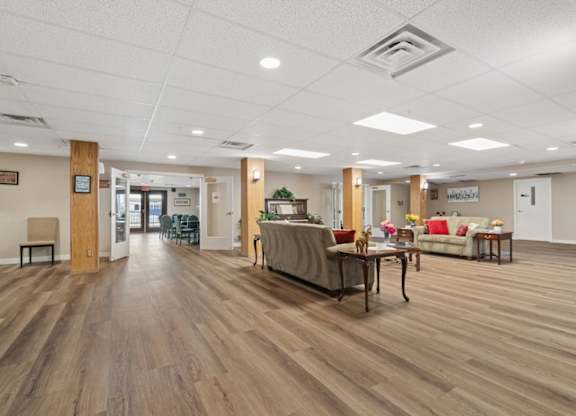 A spacious room with wooden floors and furniture.