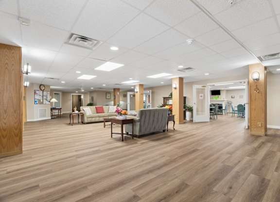 A spacious room with wooden floors and furniture.