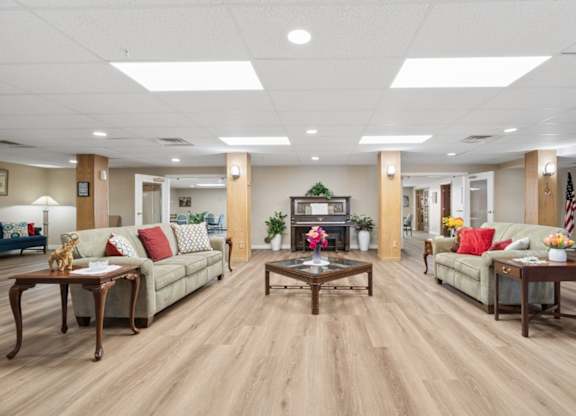 A spacious living room with wooden floors and furniture.