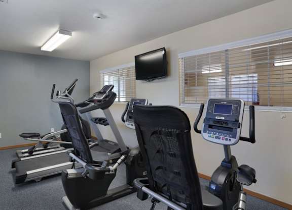 A gym room with treadmills and exercise bikes.