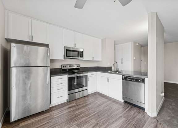 A kitchen with stainless steel appliances and white cabinets.