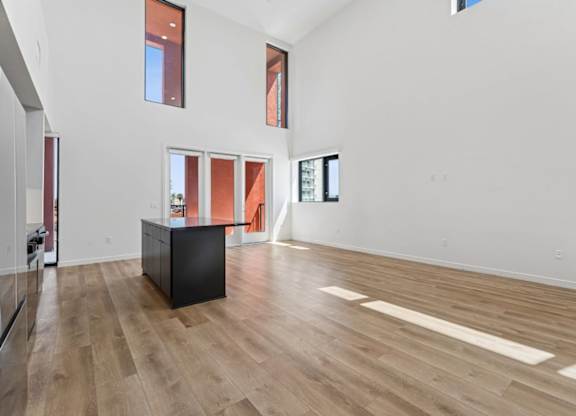 A room with a black cabinet and wooden flooring.