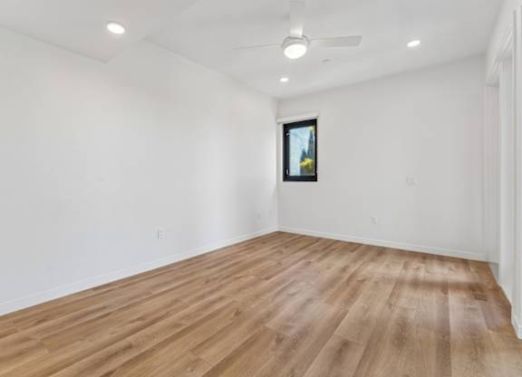 A room with wooden flooring and a ceiling fan.