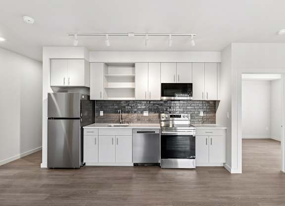 A modern kitchen with stainless steel appliances and white cabinetry.