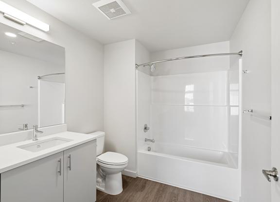 A white bathroom with a toilet, sink, and bathtub.