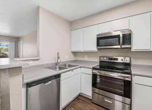 A kitchen with a stainless steel dishwasher and oven.