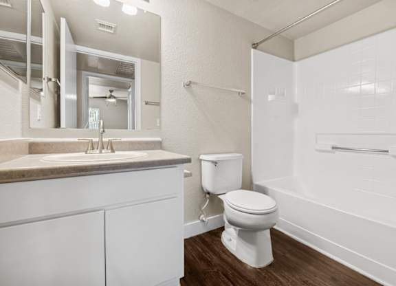 A white bathroom with a toilet, sink, and bathtub.