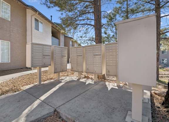 A row of mailboxes in front of apartment buildings.