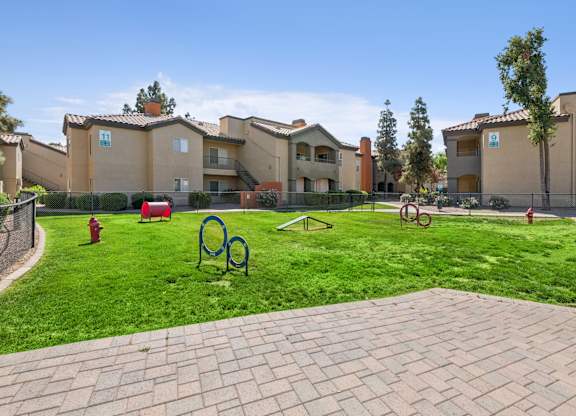 A park area with a red fire hydrant and a blue monkey bar set.