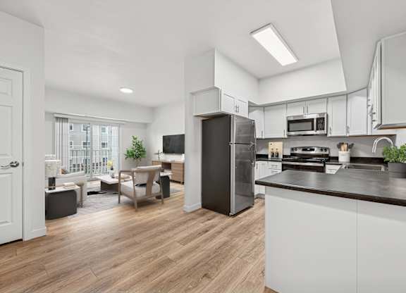 A modern kitchen with a refrigerator, stove, and microwave.