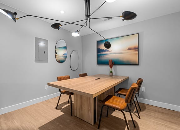 a dining room with a table and chairs and a painting on the wall