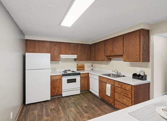 A kitchen with wooden cabinets and white appliances.