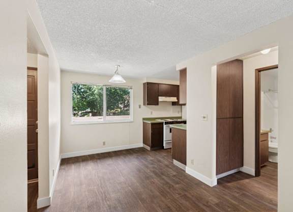 A kitchen area with brown cabinets and a window.