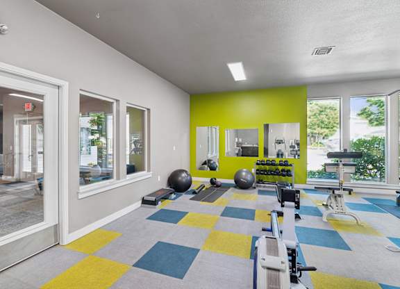 A gym with a variety of equipment including a rowing machine.