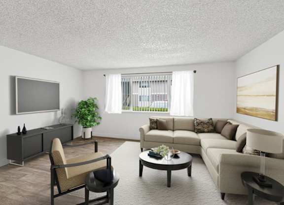A living room with a grey sofa, a brown armchair, a coffee table, and a flat screen TV mounted on the wall.