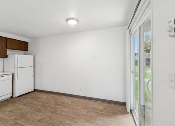 A kitchen with white appliances and wooden cabinets.