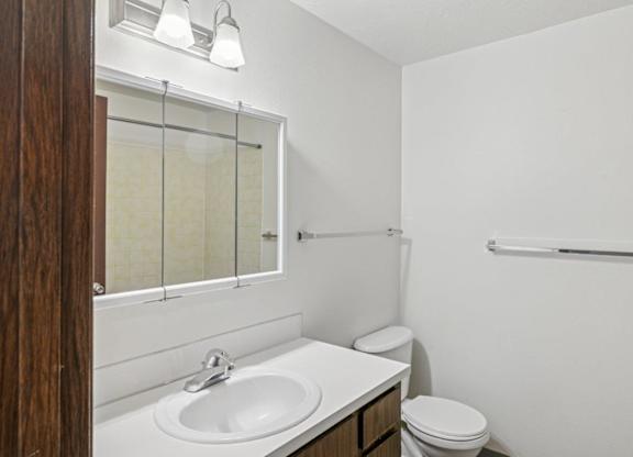 A white sink in a bathroom with a toilet and a towel rack.