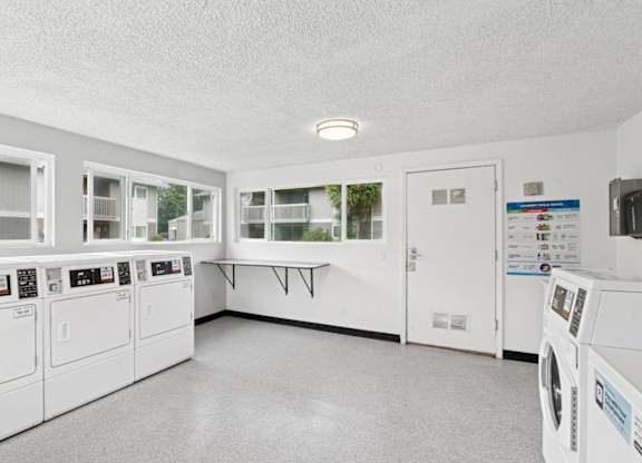 A laundry room with washers and dryers.