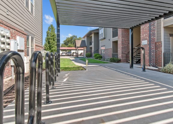a covered walkway at the whispering winds apartments in pearland, tx