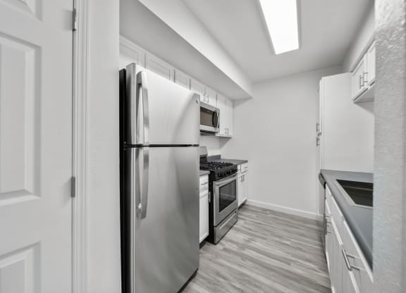 a kitchen with stainless steel appliances and white cabinets