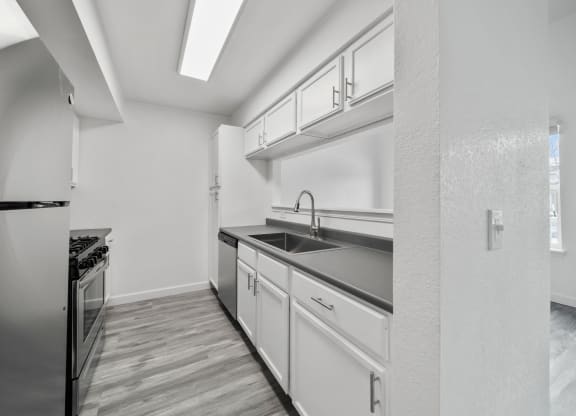 a kitchen with white cabinetry and a wooden floor