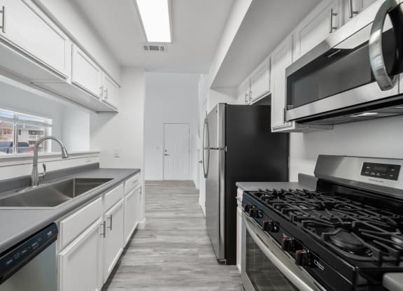 a kitchen with white cabinets and stainless steel appliances
