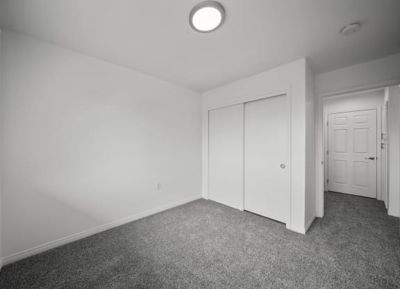 a bedroom with white walls and carpet