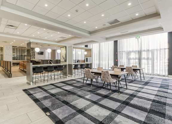A large room with a checkered floor and tables and chairs.