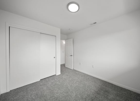 a bedroom with white walls and carpet
