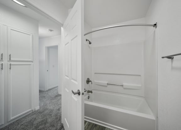 a bathroom with a white door and a white bathtub