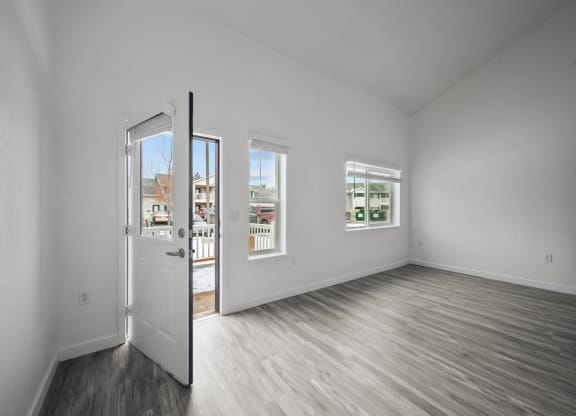 a bedroom with hardwood floors and white walls