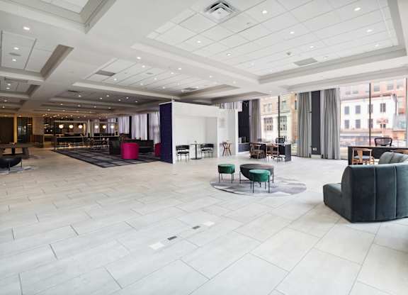 A spacious room with a white floor and a large window.