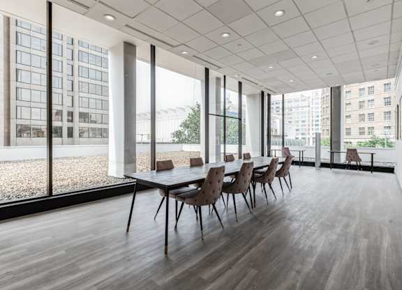 A conference room with a long table and chairs is shown.