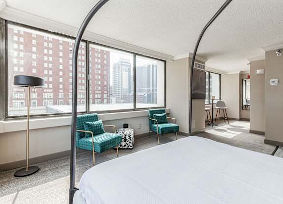 A bedroom with a large bed and a view of the city.