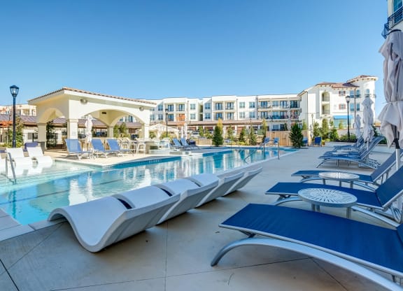 The Dylan  resort style pool with lounge chairs and umbrellas