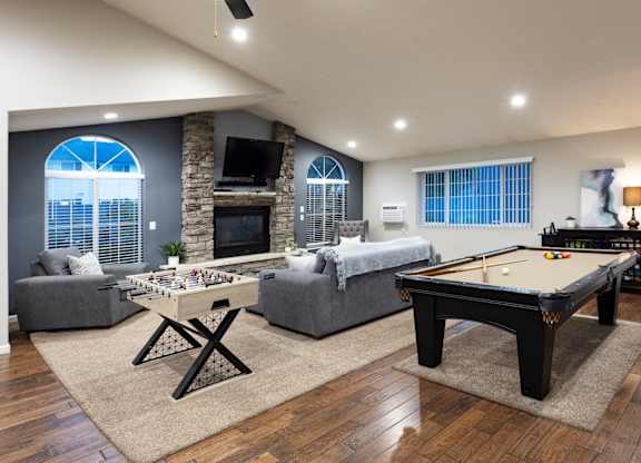 A pool table is in the middle of a living room.