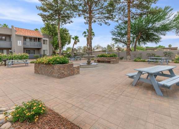 A courtyard with a picnic table and apartment buildings in the background.